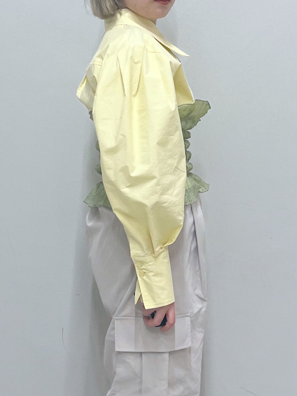 ベージュ系のカーゴパンツ、ゴールド系のパンプス、グリーン系のキャミソールを着用したレディースの春コーディネートの6枚目の写真