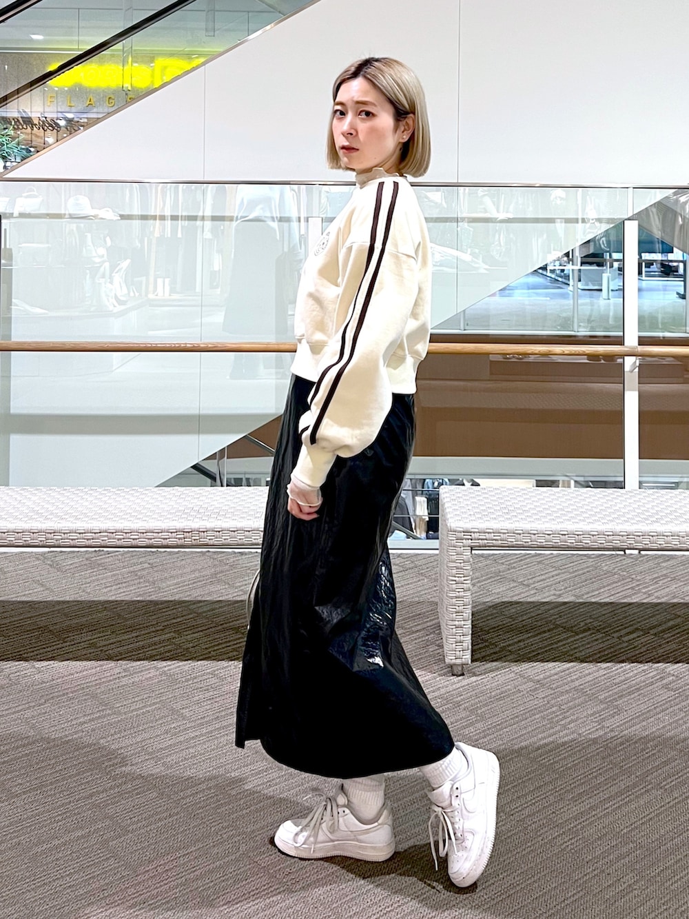 シルバー系のスカート、ピンク系のハンドバッグ、ホワイト系のスウェットを着用したレディースの冬コーディネートの3枚目の写真