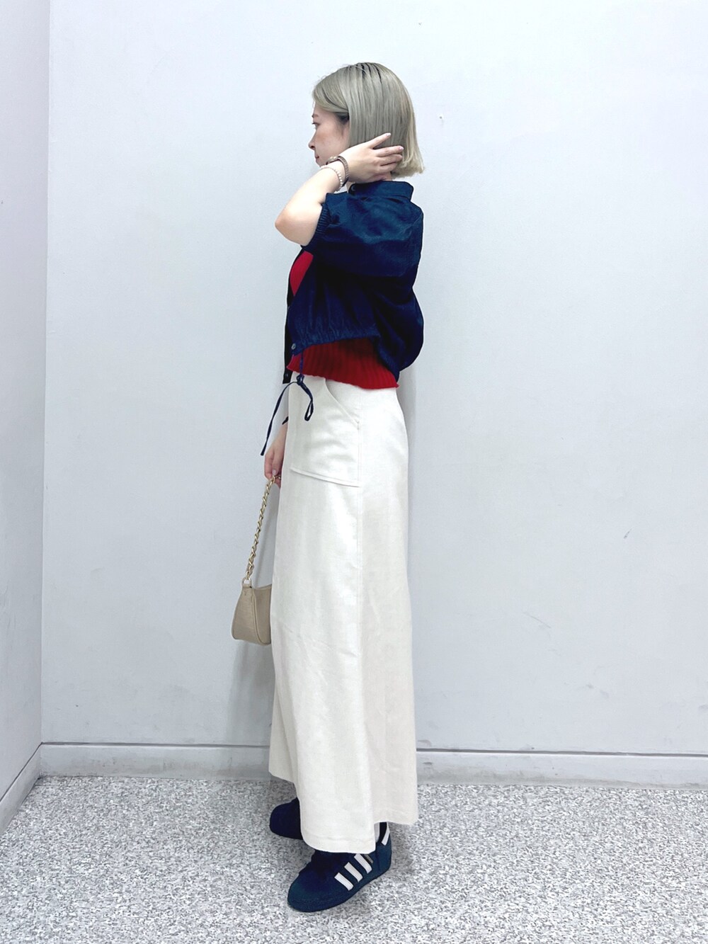 ホワイト系のスカート、ベージュ系のトートバッグ、レッド系のタンクトップを着用したレディースの秋コーディネートの2枚目の写真