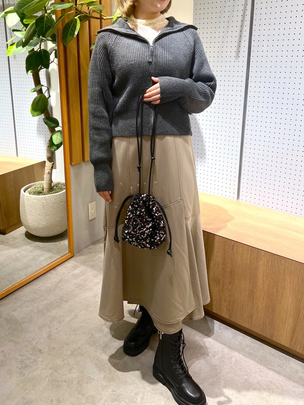 ブラック系のブーツ、ブラウン系のワンピース、ホワイト系のTシャツ/カットソーを着用したレディースの秋コーディネートの5枚目の写真