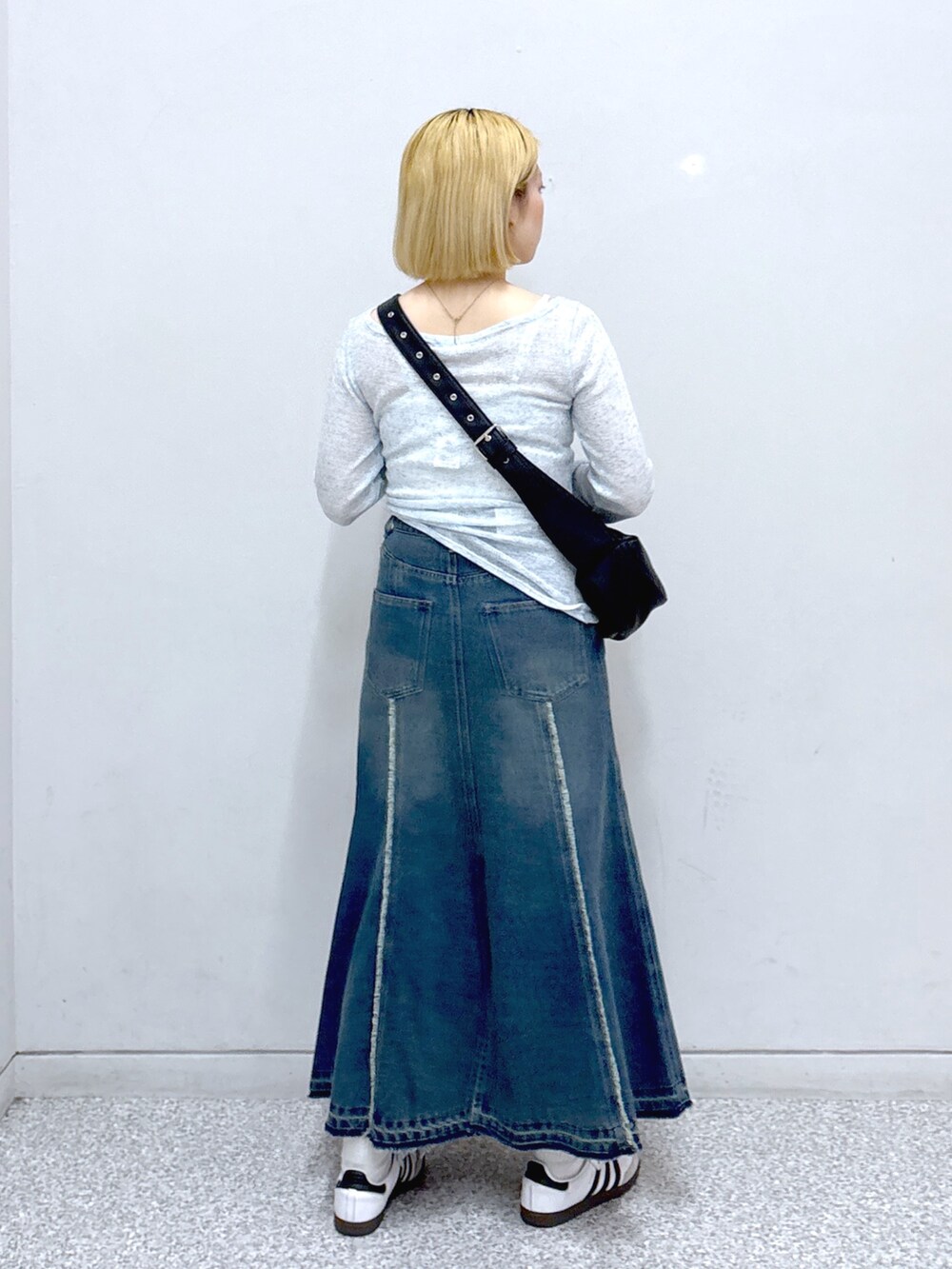 ブルー系のスカート、ブラック系のショルダーバッグ、ブルー系のTシャツ/カットソーを着用したレディースの春コーディネートの3枚目の写真