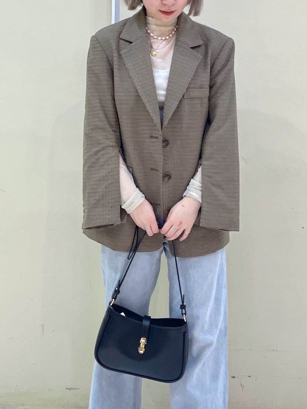 ブラウン系のテーラードジャケット、ホワイト系のTシャツ/カットソー、ベージュ系のショルダーバッグを着用したレディースの春コーディネートの5枚目の写真