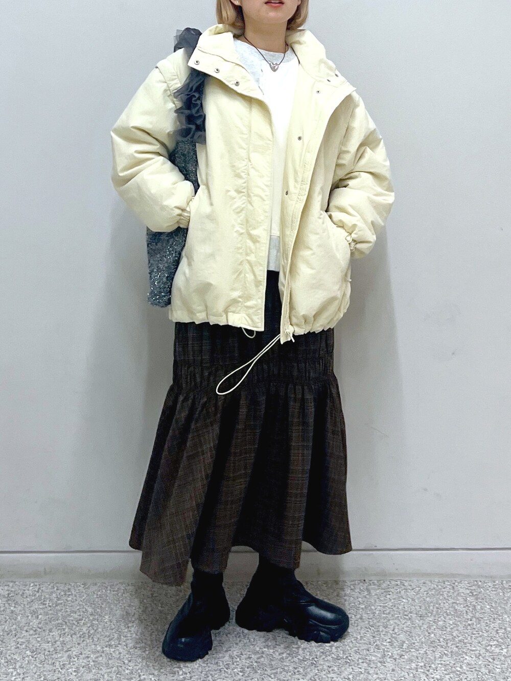 ホワイト系のスウェット、ホワイト系のダウンジャケット/コート、ブラウン系のスカートを着用したレディースの秋コーディネートの7枚目の写真