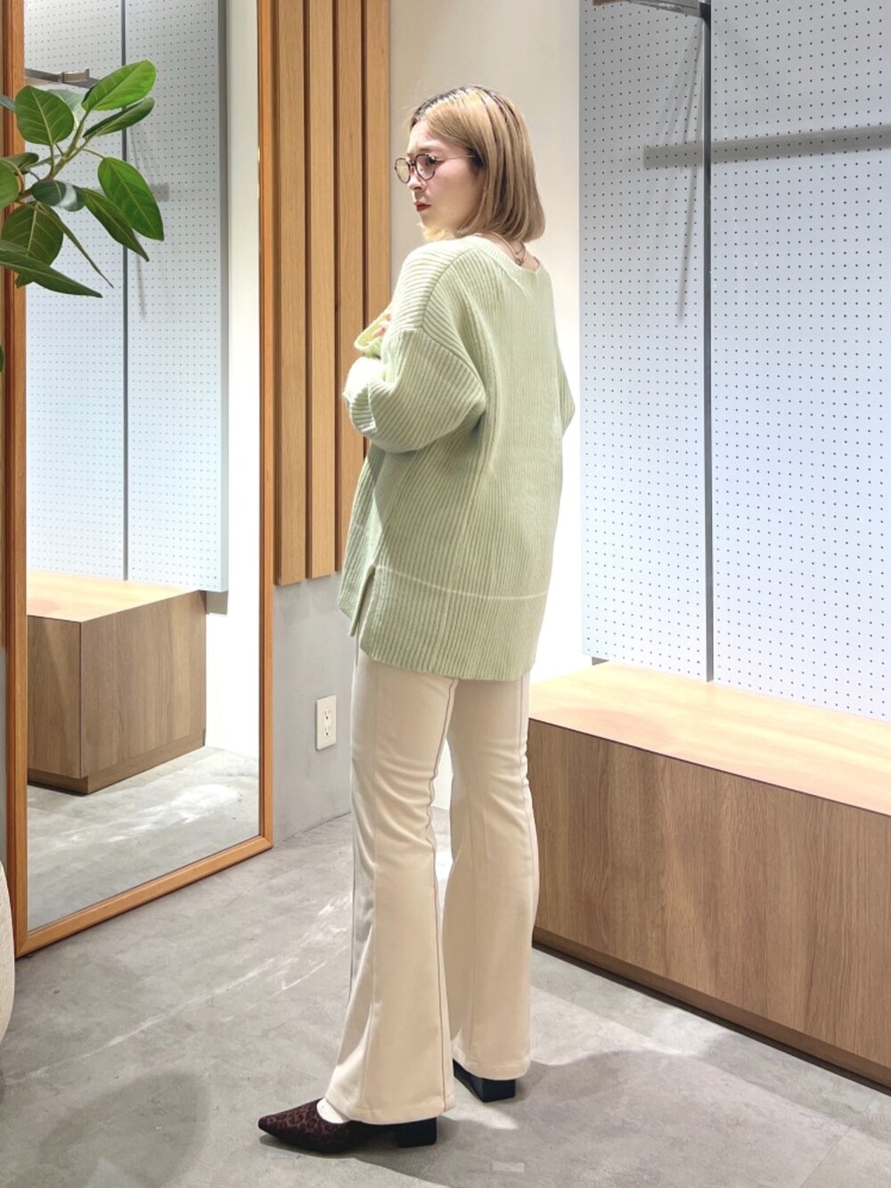 ブラウン系のバレエシューズ、ベージュ系のその他パンツ、グリーン系のニット/セーターを着用したレディースの冬コーディネートの3枚目の写真