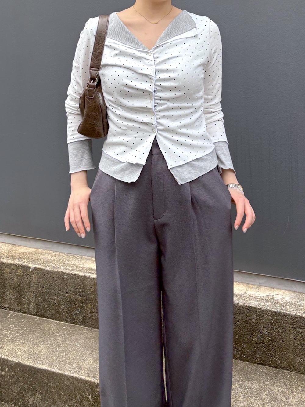 グレー系のスラックス、ホワイト系のTシャツ/カットソーを着用したレディースの夏コーディネートの4枚目の写真