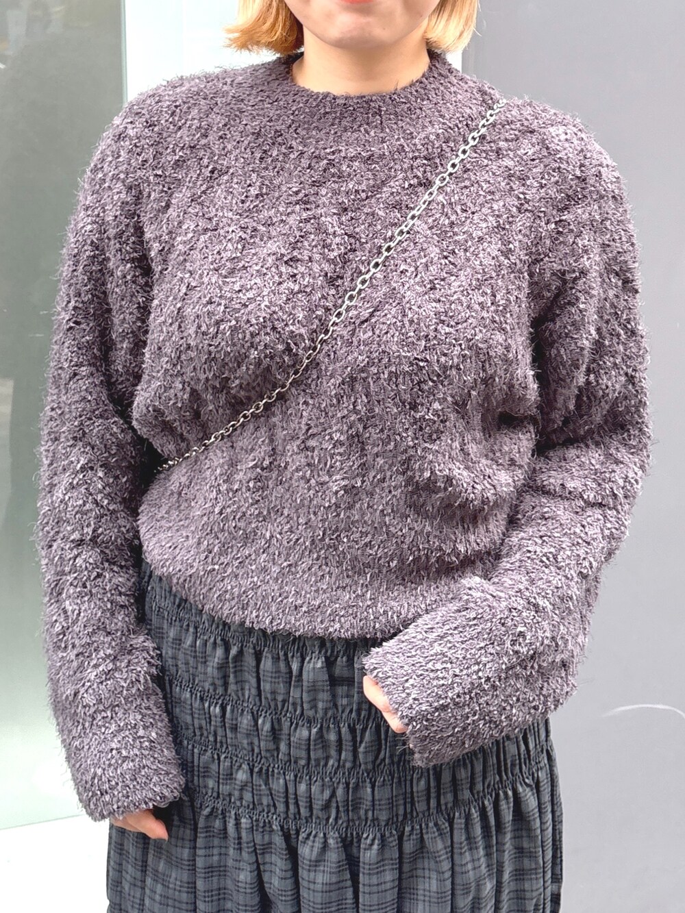 グレー系のスカート、グレー系のニット/セーター、ブラック系のショルダーバッグを着用したレディースの冬コーディネートの4枚目の写真