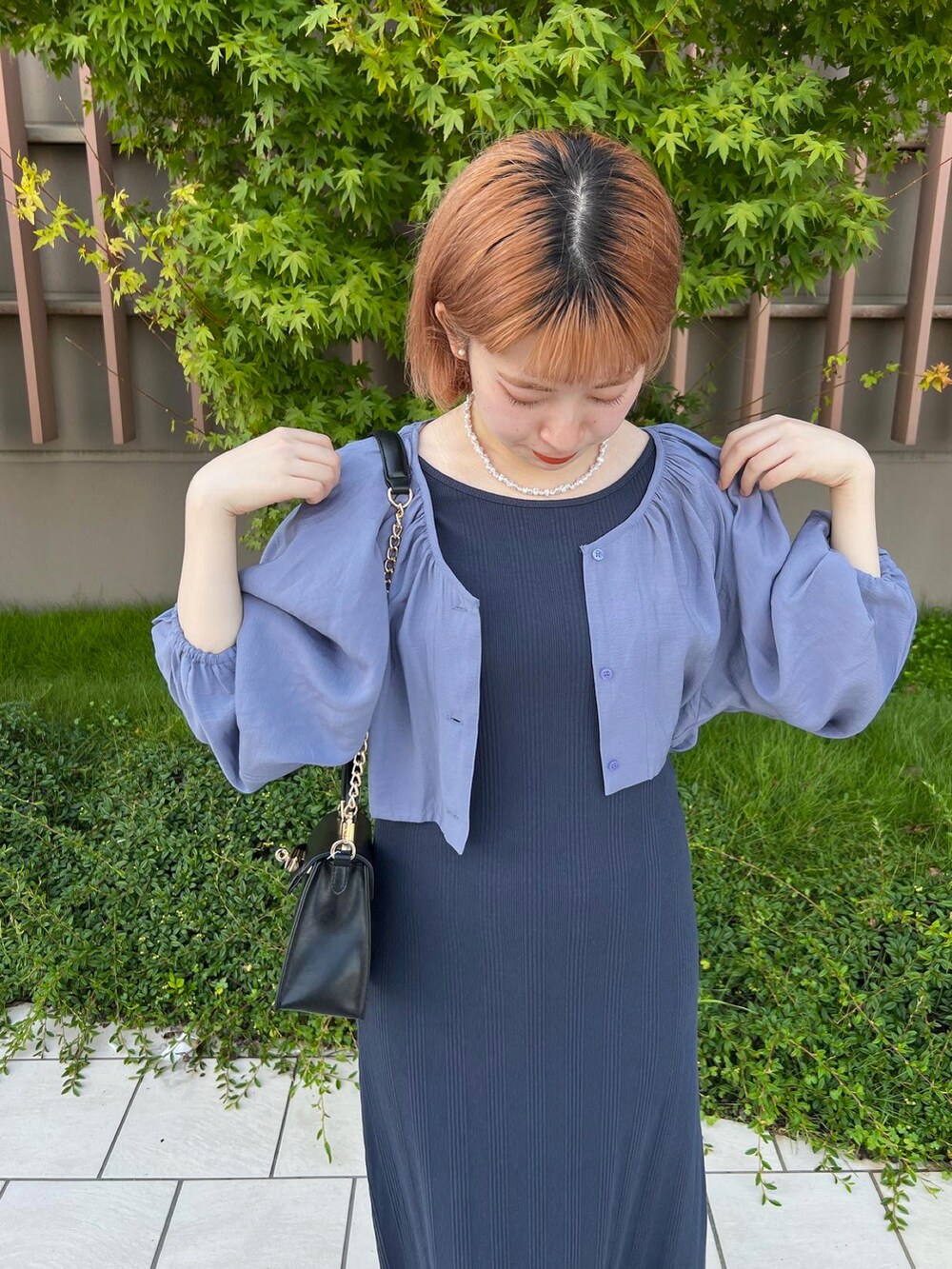 ブルー系のワンピース、ブラック系のハンドバッグを着用したレディースの秋コーディネートの2枚目の写真