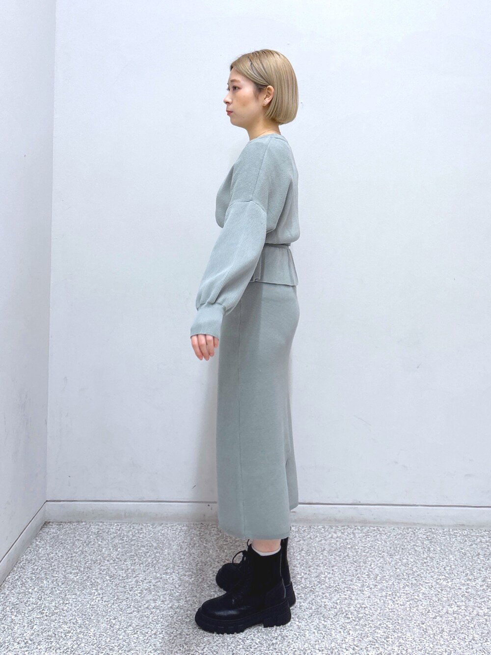 グリーン系のワンピース、ホワイト系のその他アウター、ブラック系のベルトを着用したレディースの冬コーディネートの4枚目の写真