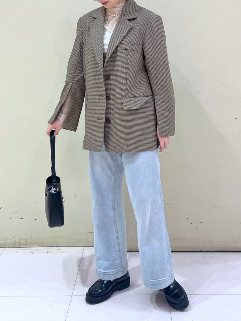 ブラウン系のテーラードジャケット、ホワイト系のTシャツ/カットソー、ベージュ系のショルダーバッグを着用したレディースの春コーディネートの4枚目の写真