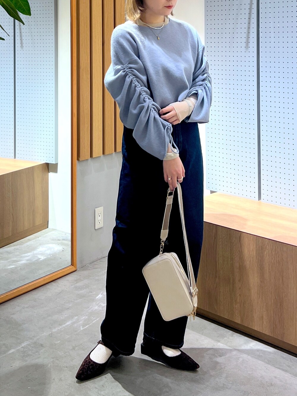 ブルー系のデニムパンツ、グレー系のボディバッグ/ウエストポーチ、ブルー系のワンピースを着用したレディースの冬コーディネートの3枚目の写真