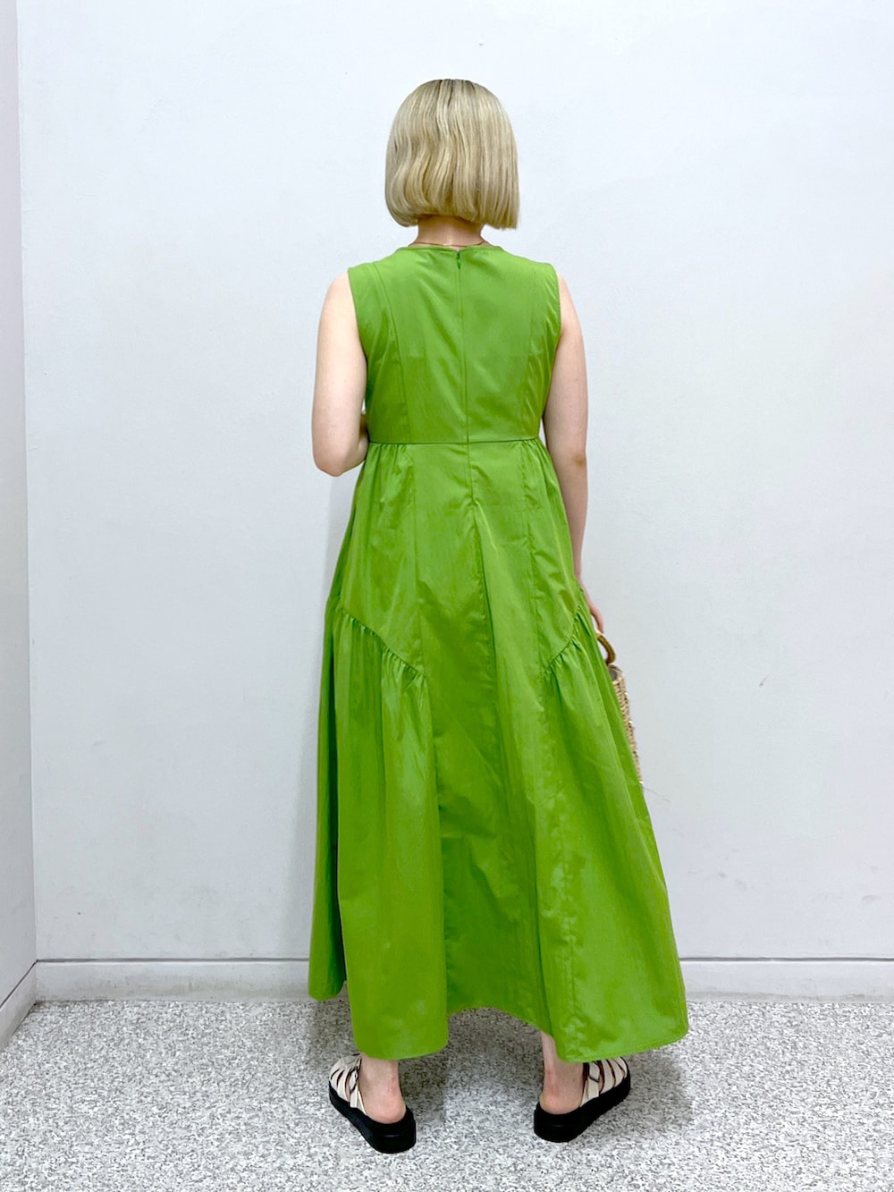 グリーン系のワンピース、イエロー系のかごバッグを着用したレディースの夏コーディネートの3枚目の写真