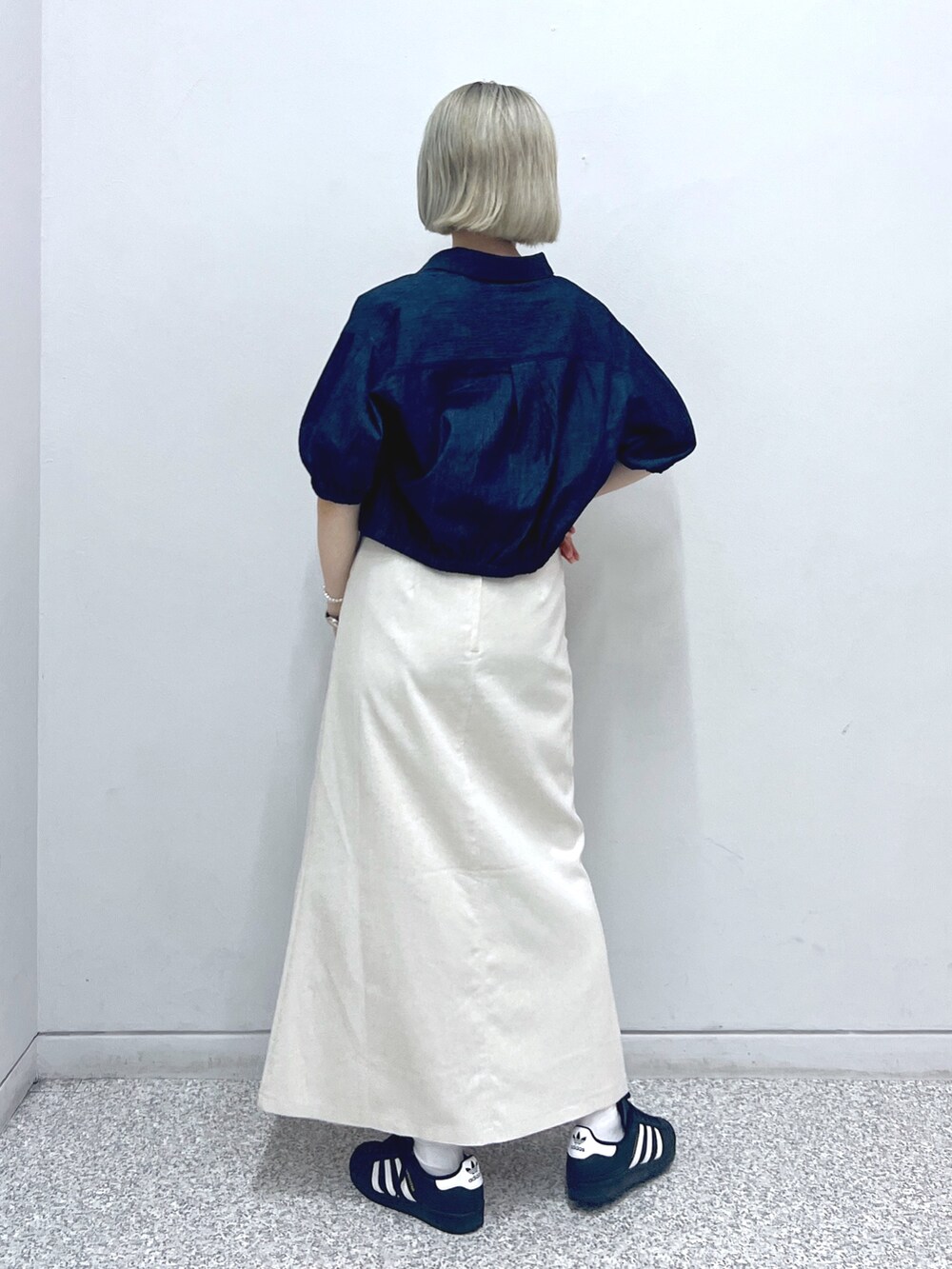 ホワイト系のスカート、ベージュ系のトートバッグ、レッド系のタンクトップを着用したレディースの秋コーディネートの3枚目の写真