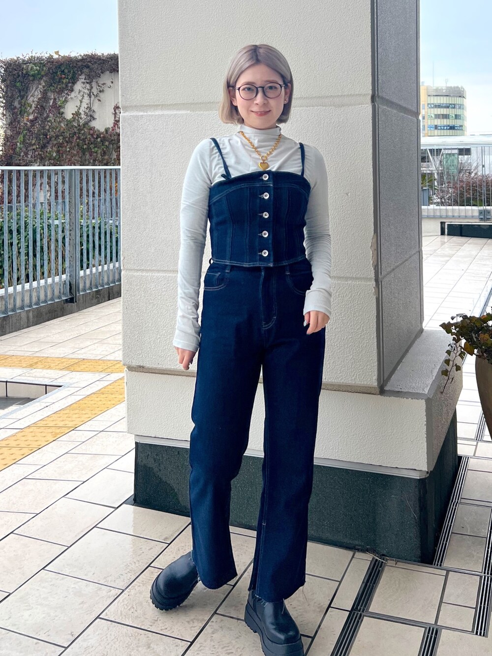 ブルー系のデニムパンツ、ホワイト系のTシャツ/カットソー、ブルー系のベストを着用したレディースの冬コーディネートの2枚目の写真