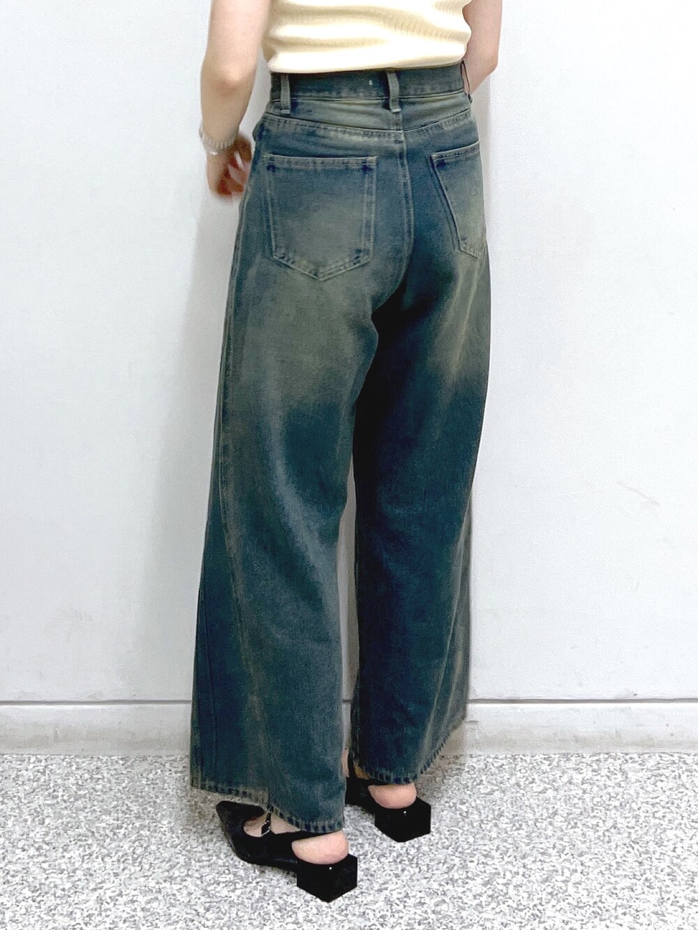 ブルー系のデニムパンツ、ブラック系のパンプス、ベージュ系のトートバッグを着用したレディースの夏コーディネートの6枚目の写真