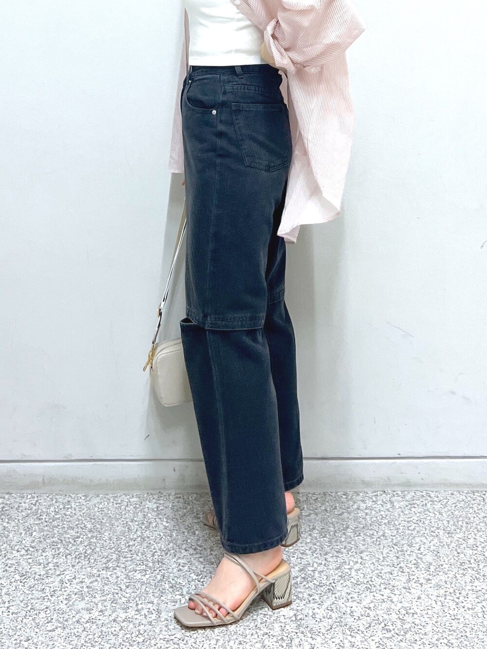 ブラック系のデニムパンツ、グレー系のサンダル、ホワイト系のハンドバッグを着用したレディースの夏コーディネートの6枚目の写真