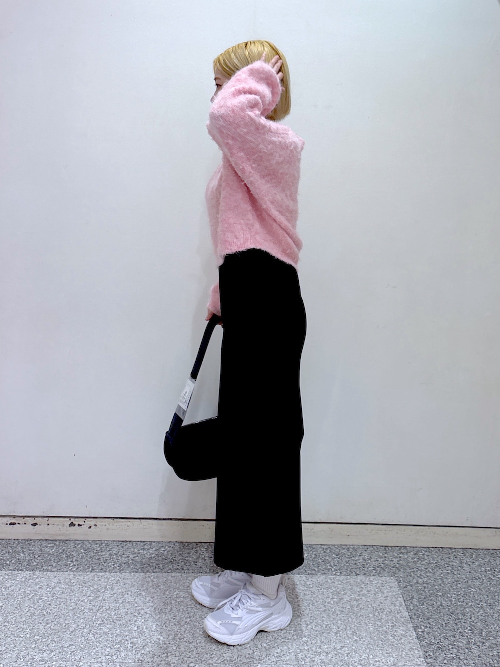 ピンク系のニット/セーター、ブラック系のスカート、ブラック系のショルダーバッグを着用したレディースの冬コーディネートの2枚目の写真