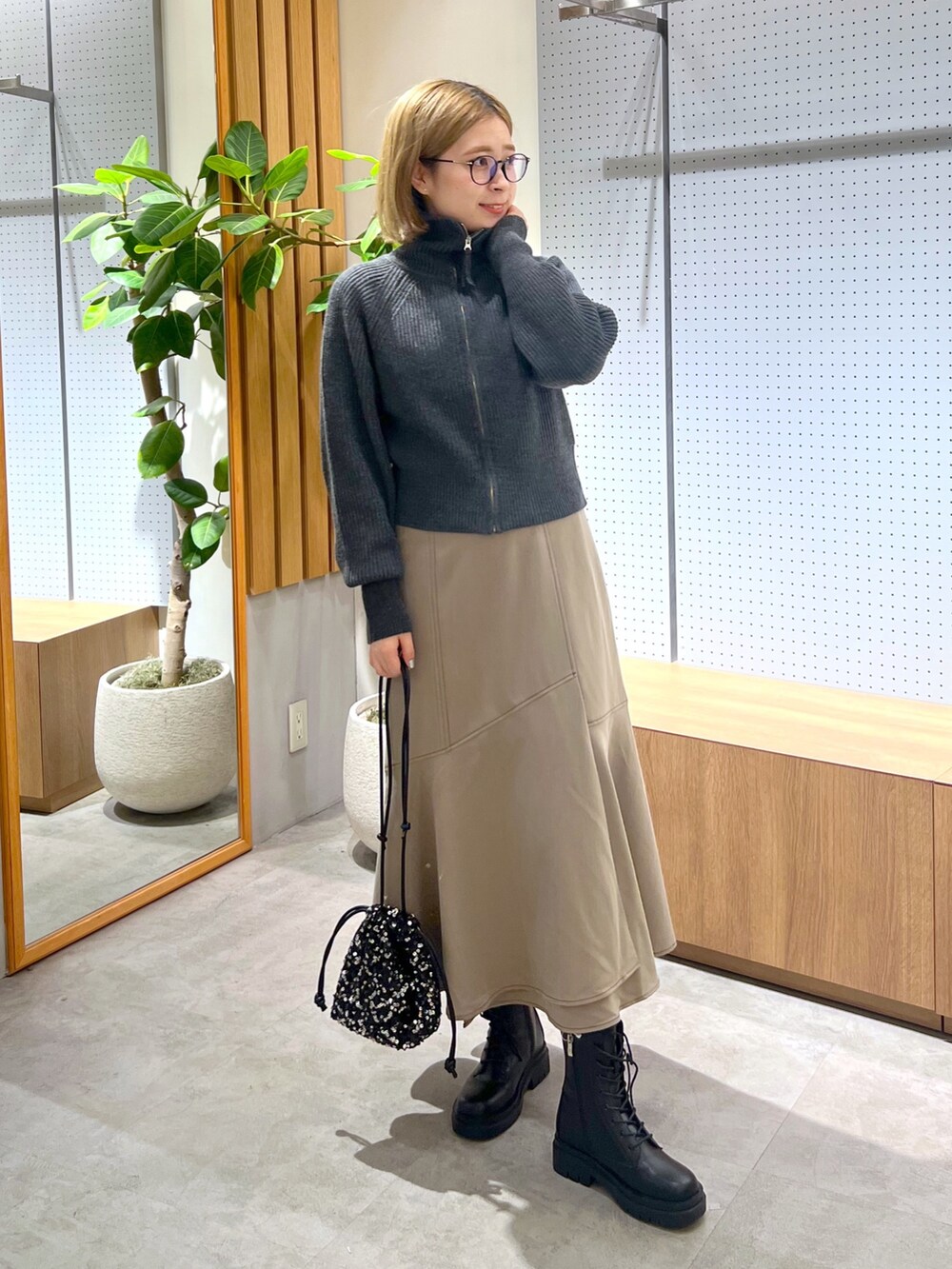 ブラック系のブーツ、ブラウン系のワンピース、ホワイト系のTシャツ/カットソーを着用したレディースの秋コーディネートの2枚目の写真