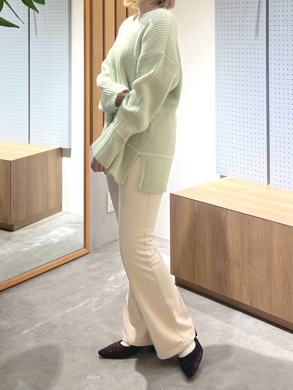 ブラウン系のバレエシューズ、ベージュ系のその他パンツ、グリーン系のニット/セーターを着用したレディースの冬コーディネートの2枚目の写真