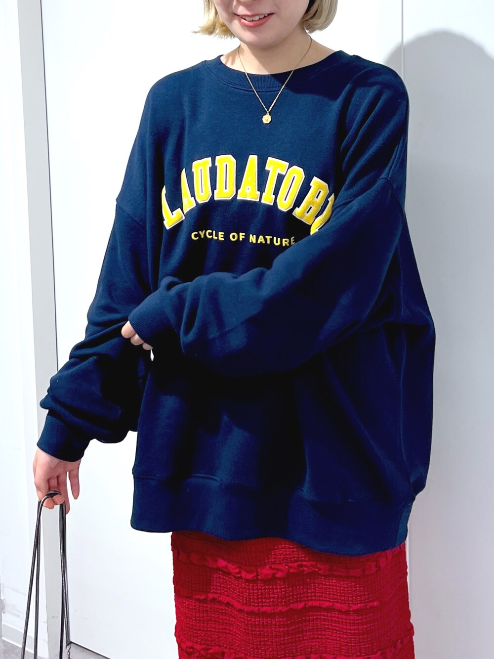 レッド系のスカート、ブルー系のスウェットを着用したレディースの秋コーディネートの4枚目の写真