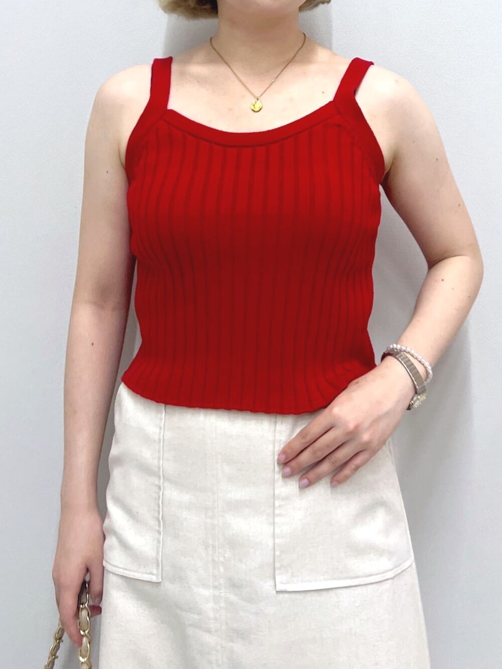 ホワイト系のスカート、ベージュ系のトートバッグ、レッド系のタンクトップを着用したレディースの秋コーディネートの5枚目の写真