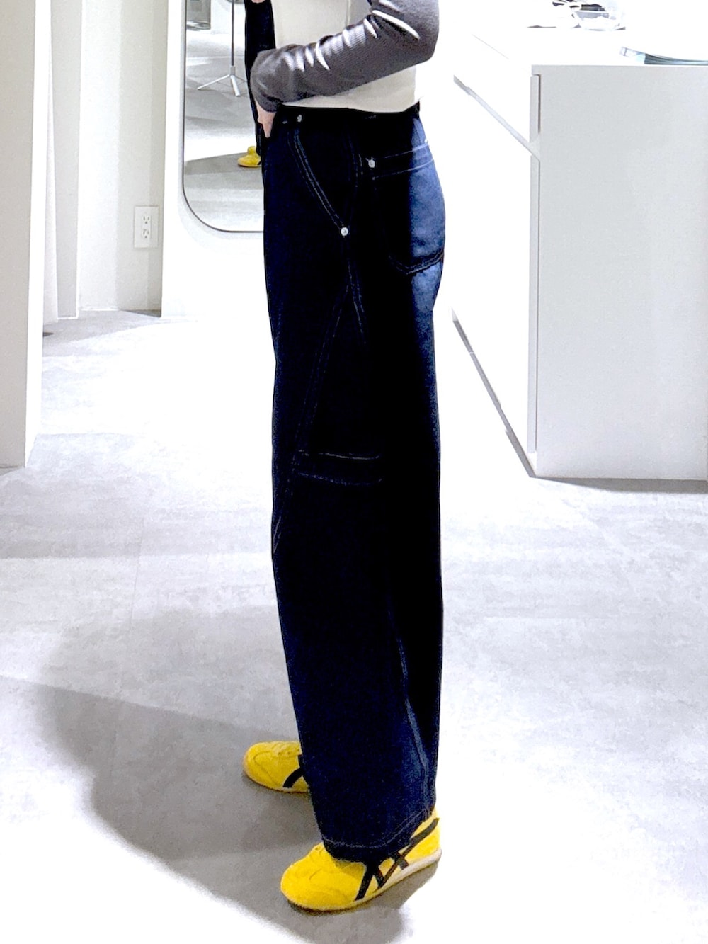 ブルー系のデニムパンツ、ブラック系のショルダーバッグ、ブラウン系のブルゾンを着用したレディースの冬コーディネートの5枚目の写真