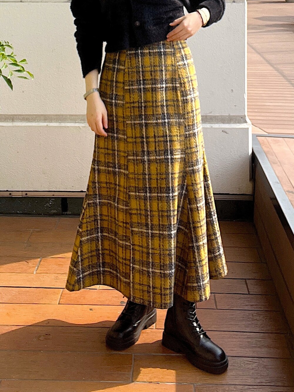 ホワイト系のニット/セーター、イエロー系のスカート、ブラック系のブーツを着用したレディースの秋コーディネートの7枚目の写真