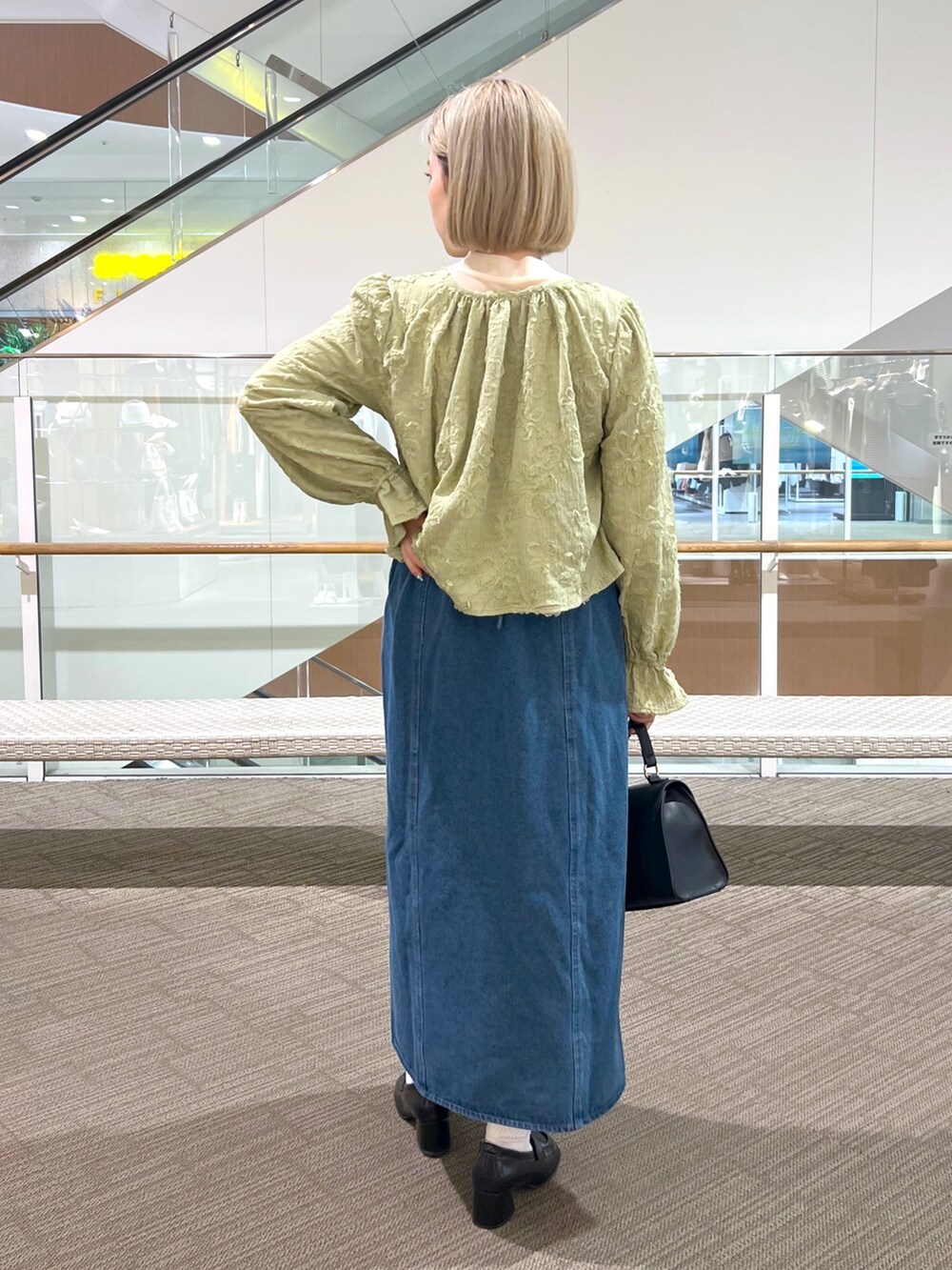 ブルー系のワンピース、ブラック系のローファー、ブラック系のショルダーバッグを着用したレディースの冬コーディネートの4枚目の写真