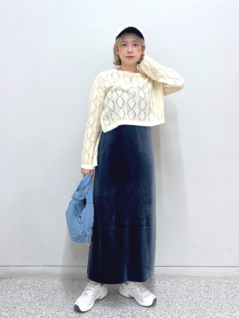 グレー系のワンピース、ホワイト系のニット/セーター、ブルー系のハンドバッグを着用したレディースの秋コーディネートの2枚目の写真