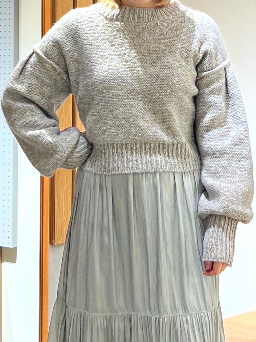 グレー系のニット/セーター、グリーン系のスカート、ホワイト系のニットキャップ/ビーニーを着用したレディースの冬コーディネートの4枚目の写真