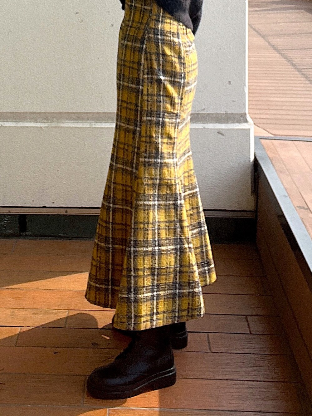 ホワイト系のニット/セーター、イエロー系のスカート、ブラック系のブーツを着用したレディースの秋コーディネートの6枚目の写真