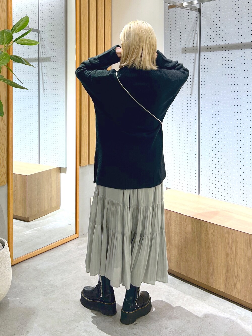 ブラック系のニット/セーター、シルバー系のショルダーバッグ、ホワイト系のスカートを着用したレディースの冬コーディネートの4枚目の写真