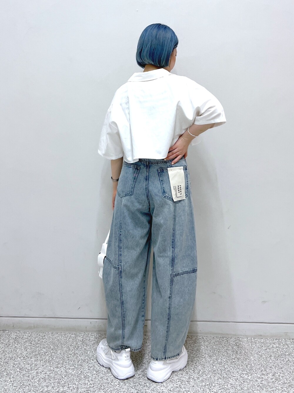 ホワイト系のハンドバッグ、ブルー系のデニムパンツ、ホワイト系のシャツ/ブラウスを着用したレディースの夏コーディネートの2枚目の写真