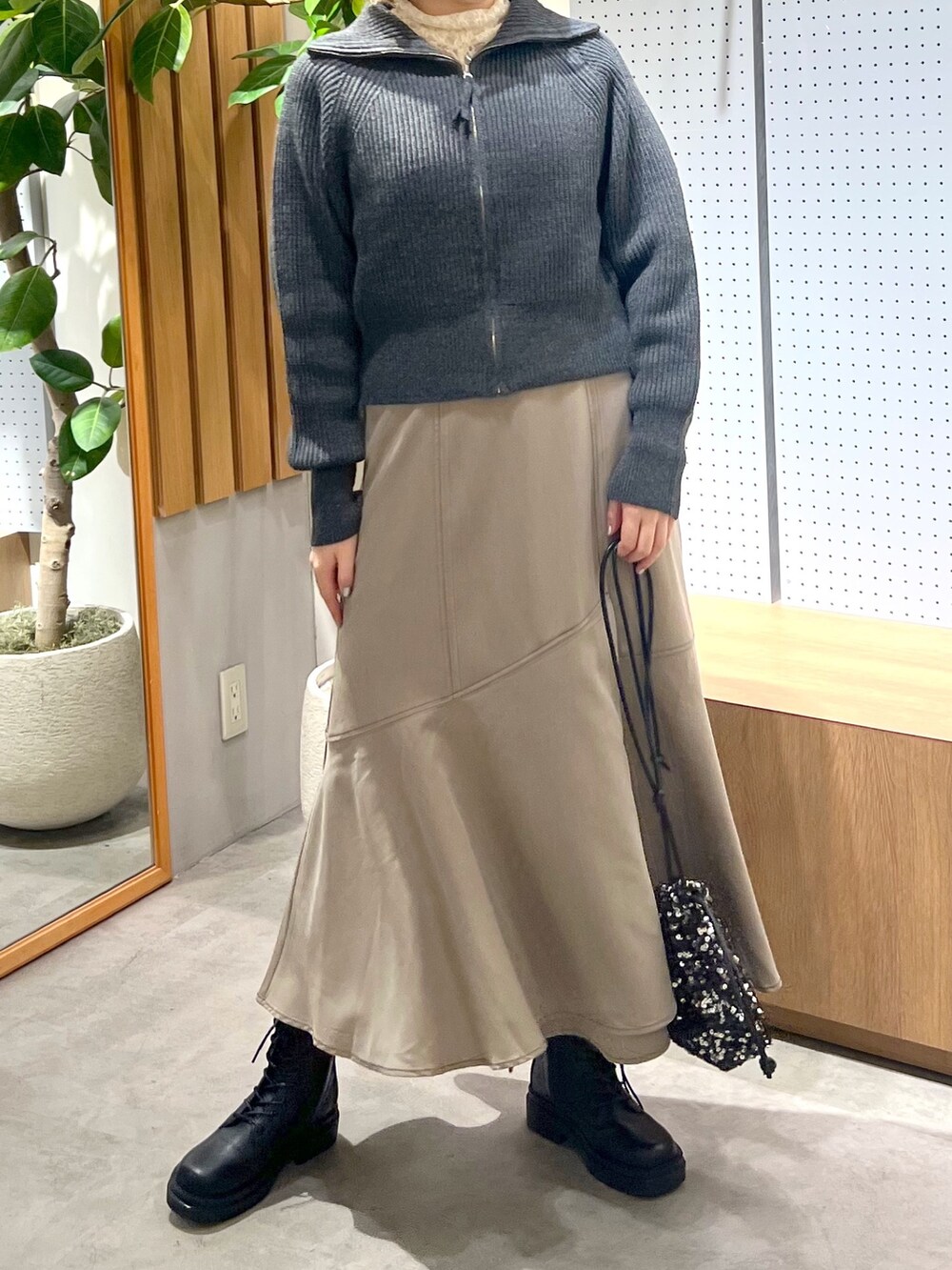 ブラック系のブーツ、ブラウン系のワンピース、ホワイト系のTシャツ/カットソーを着用したレディースの秋コーディネートの6枚目の写真