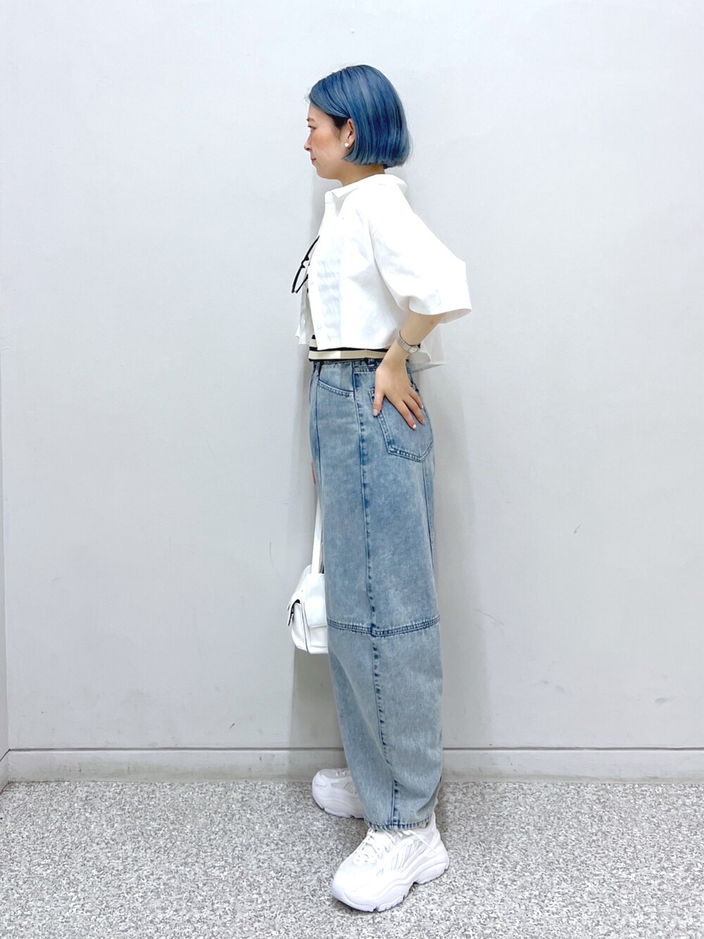 ホワイト系のハンドバッグ、ブルー系のデニムパンツ、ホワイト系のシャツ/ブラウスを着用したレディースの夏コーディネートの3枚目の写真