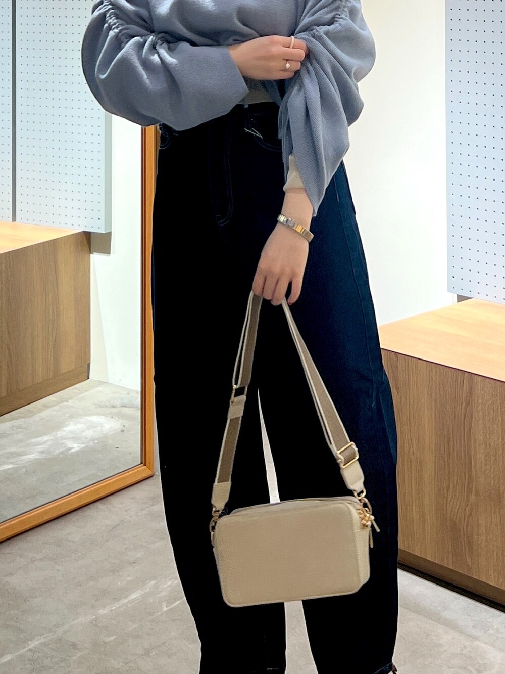 ブルー系のデニムパンツ、グレー系のボディバッグ/ウエストポーチ、ブルー系のワンピースを着用したレディースの冬コーディネートの4枚目の写真