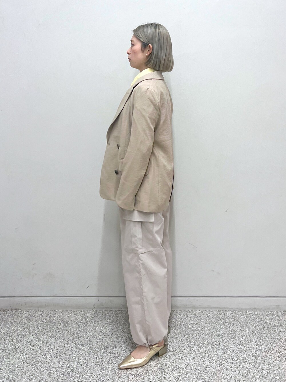 ベージュ系のカーゴパンツ、ベージュ系のテーラードジャケット、イエロー系のシャツ/ブラウスを着用したレディースの春コーディネートの2枚目の写真