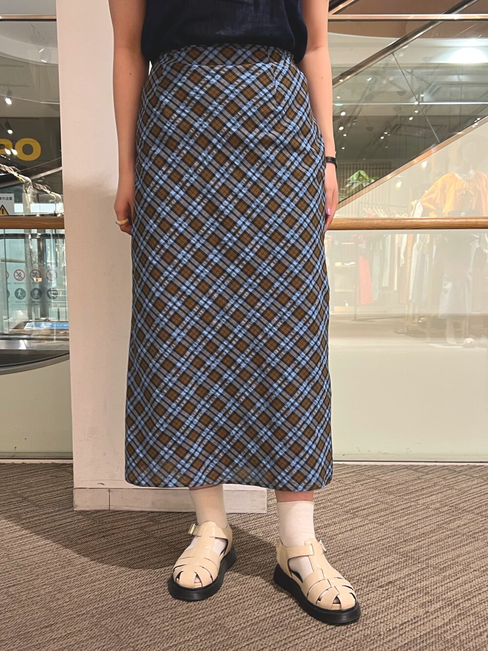 ホワイト系のサンダル、ブラウン系のスカート、ブルー系のシャツ/ブラウスを着用したレディースの夏コーディネートの4枚目の写真