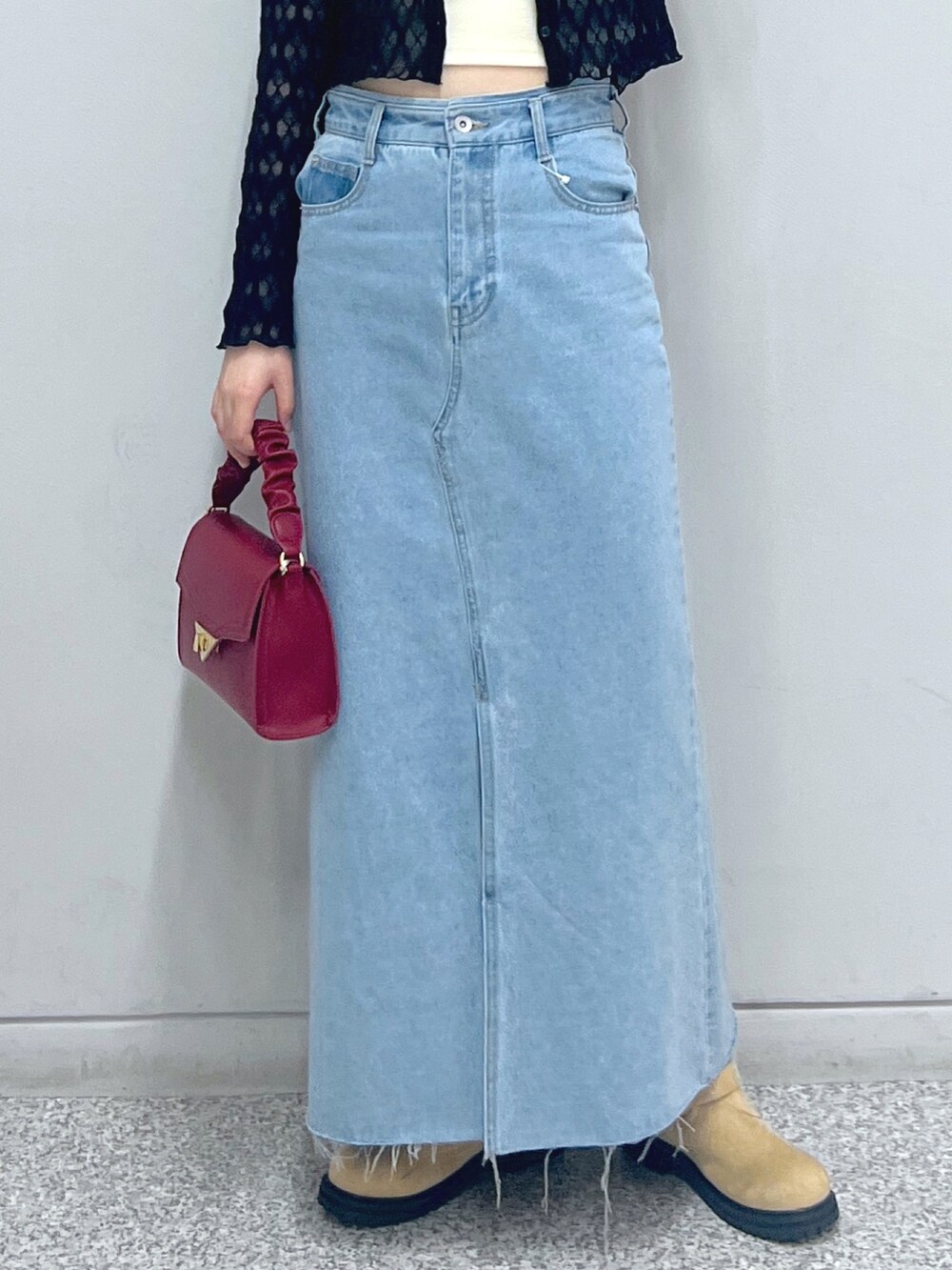 ブルー系のデニムスカート、ベージュ系のブーツ、レッド系のショルダーバッグを着用したレディースの秋コーディネートの6枚目の写真