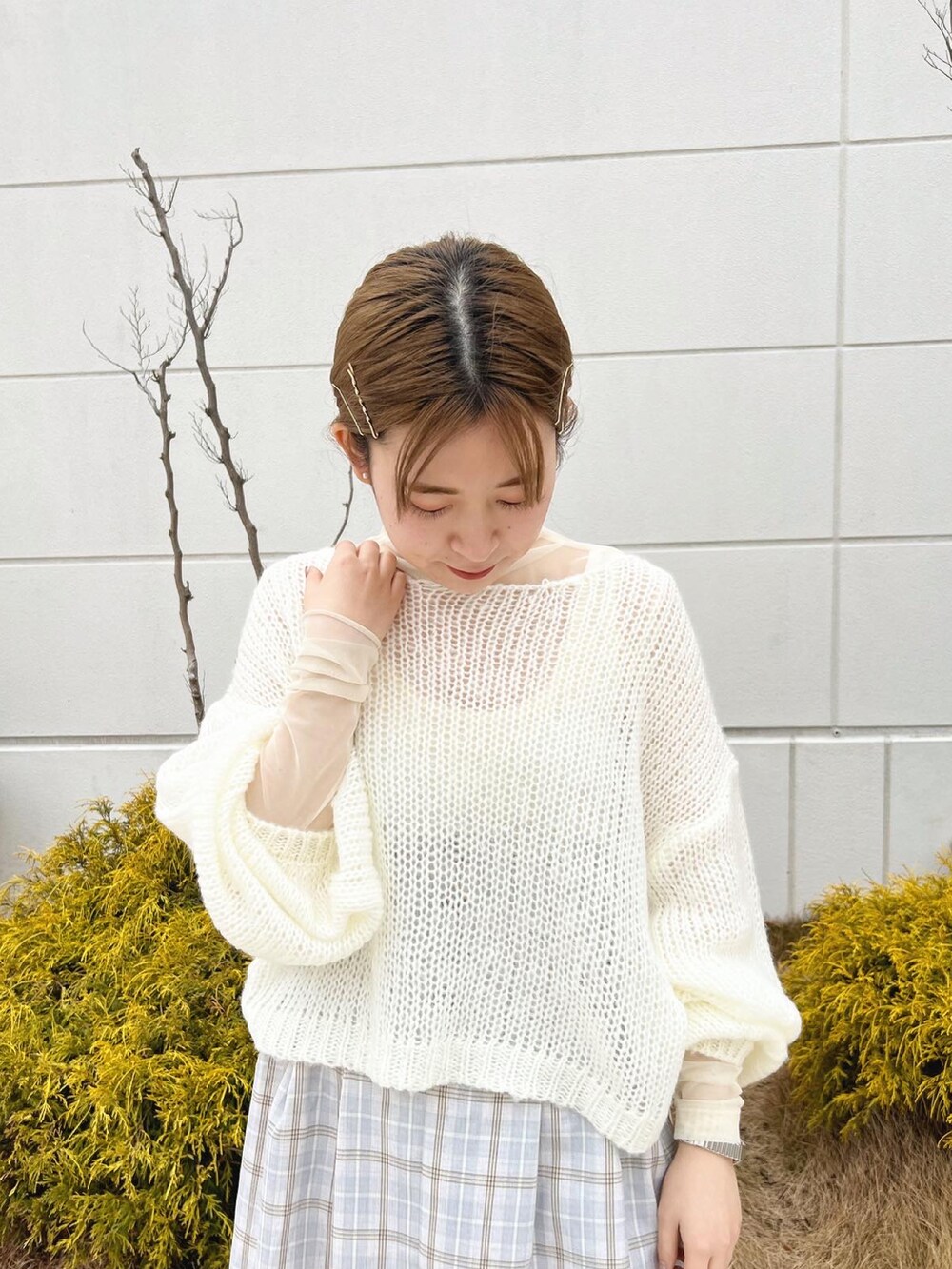 ホワイト系のニット/セーター、パープル系のスカート、ホワイト系のTシャツ/カットソーを着用したレディースの冬コーディネートの3枚目の写真