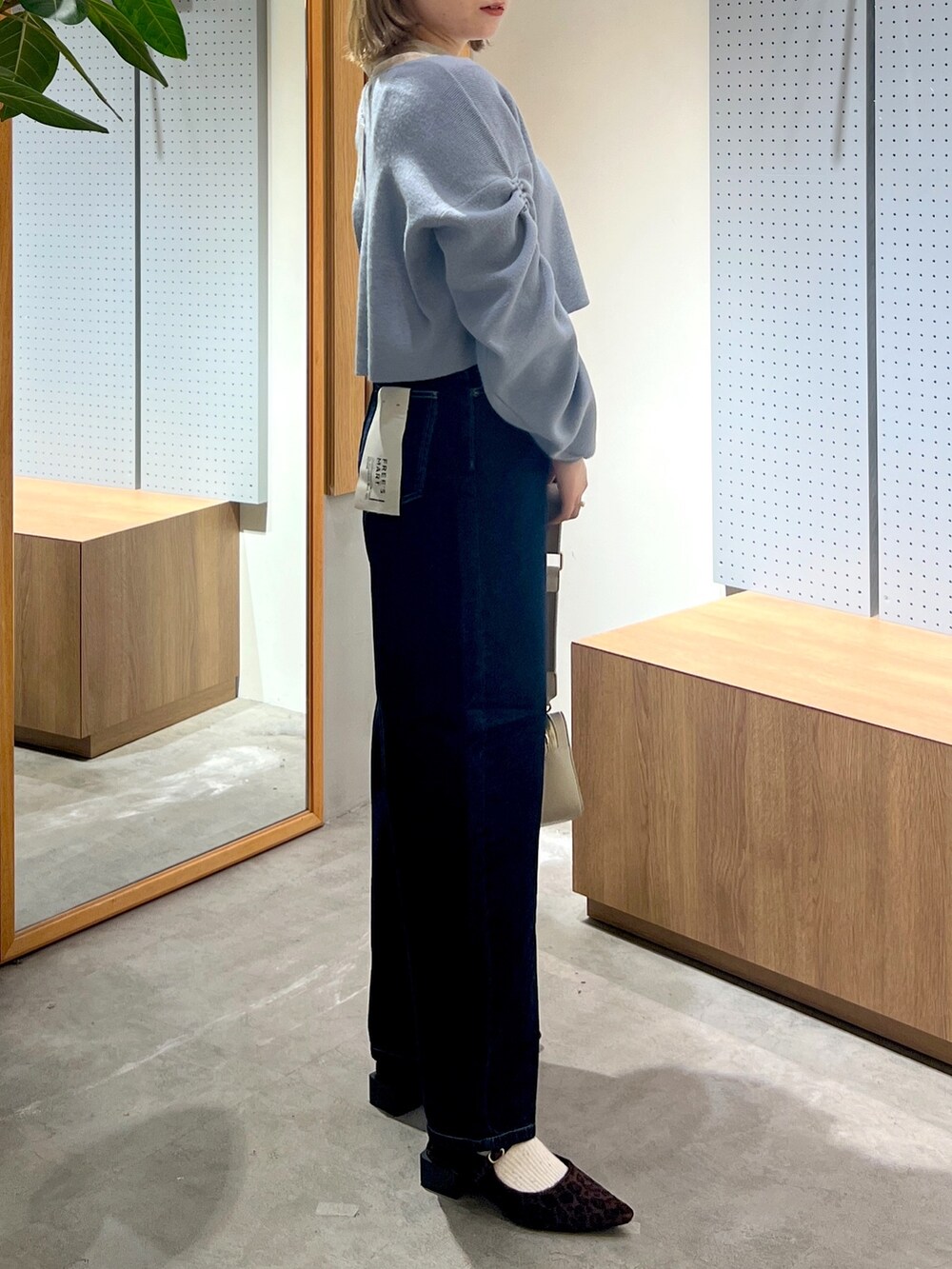 ブルー系のデニムパンツ、グレー系のボディバッグ/ウエストポーチ、ブルー系のワンピースを着用したレディースの冬コーディネートの6枚目の写真