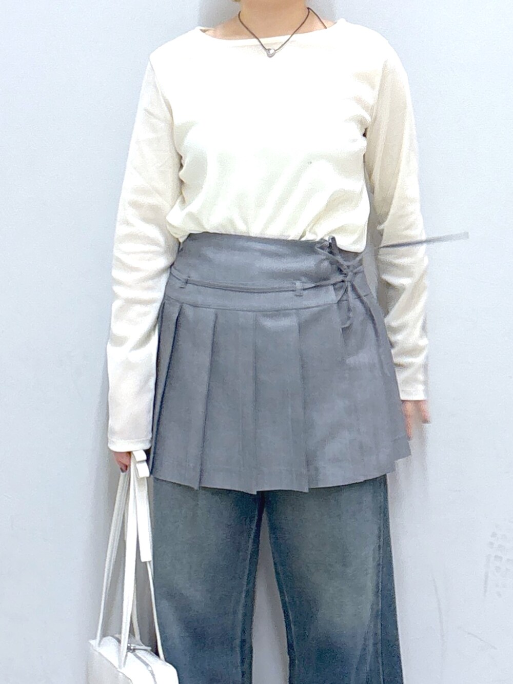 ブルー系のデニムパンツ、グレー系のスカート、グレー系のカーディガン/ボレロを着用したレディースの春コーディネートの5枚目の写真