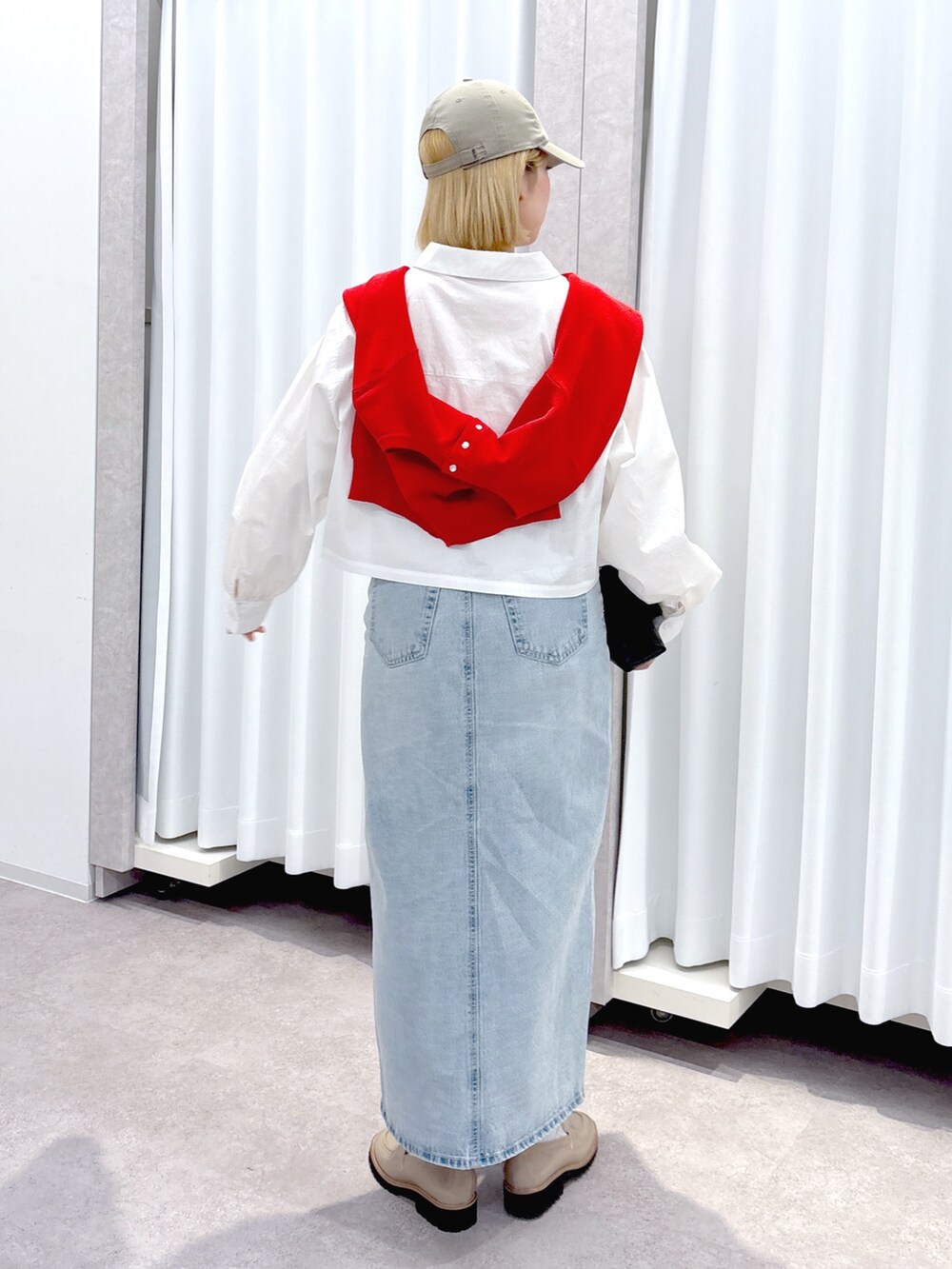 ブラック系のショルダーバッグ、ブルー系のデニムスカート、ホワイト系のシャツ/ブラウスを着用したレディースの春コーディネートの4枚目の写真