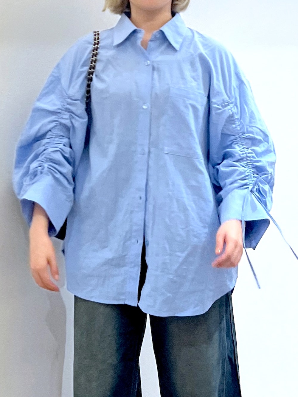 ブラック系のショルダーバッグ、ブルー系のデニムパンツ、ブルー系のテーラードジャケットを着用したレディースの秋コーディネートの6枚目の写真