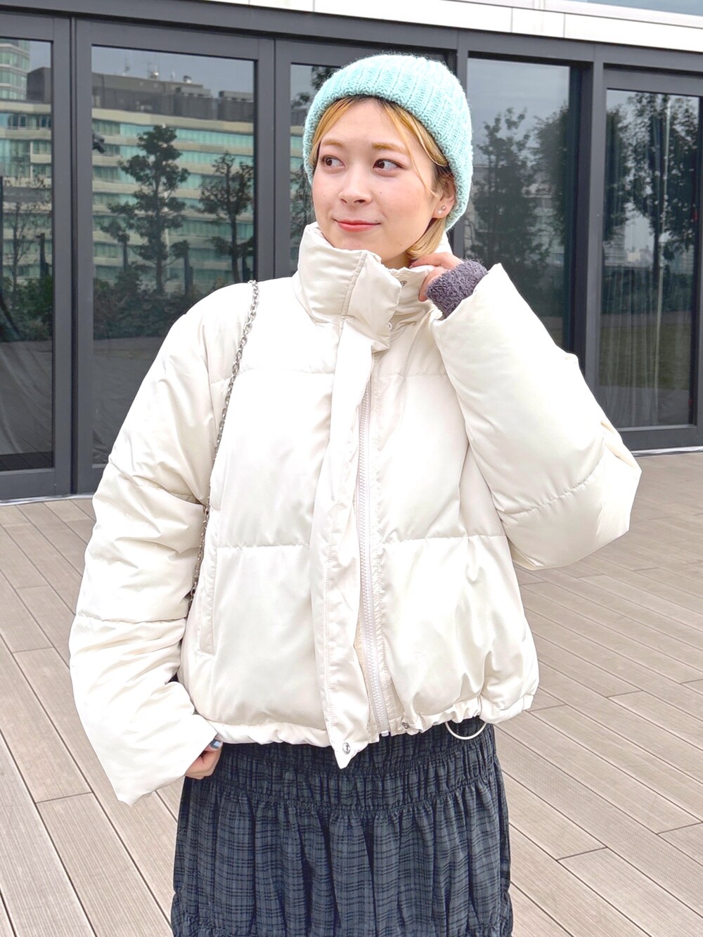 ブラック系のスカート、グリーン系のブルゾン、ブラック系のショルダーバッグを着用したレディースの冬コーディネートの3枚目の写真