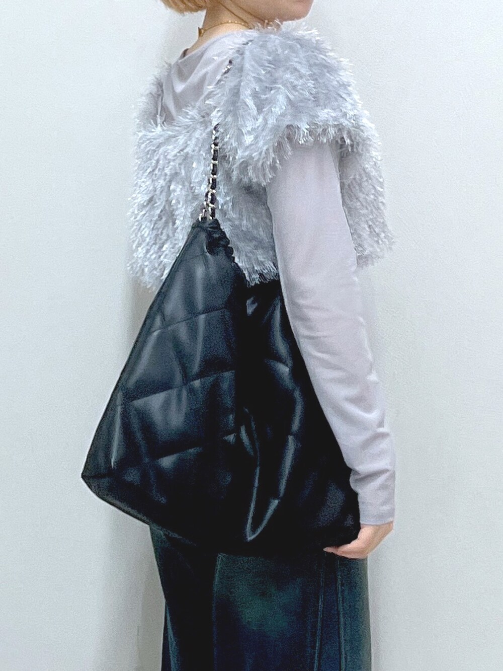 ブルー系のデニムパンツ、ベージュ系のブーツ、ブラック系のトートバッグを着用したレディースの秋コーディネートの5枚目の写真