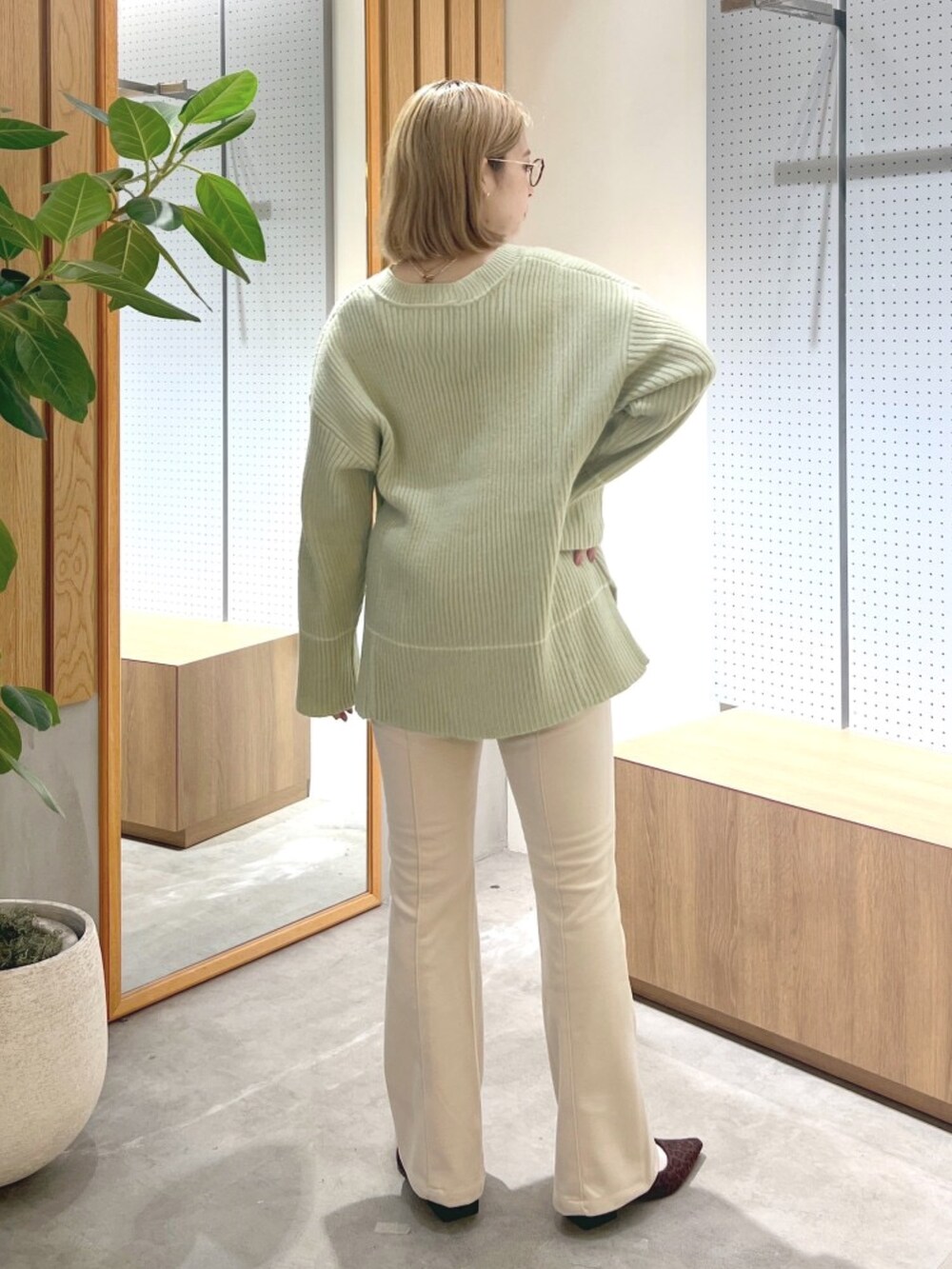 ブラウン系のバレエシューズ、ベージュ系のその他パンツ、グリーン系のニット/セーターを着用したレディースの冬コーディネートの4枚目の写真