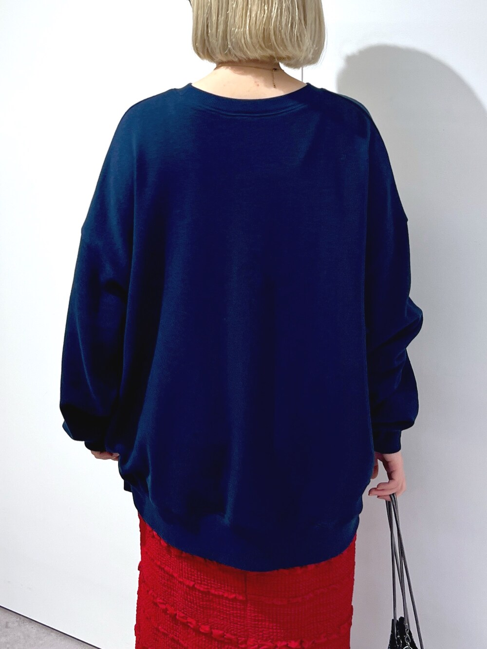 レッド系のスカート、ブルー系のスウェットを着用したレディースの秋コーディネートの5枚目の写真