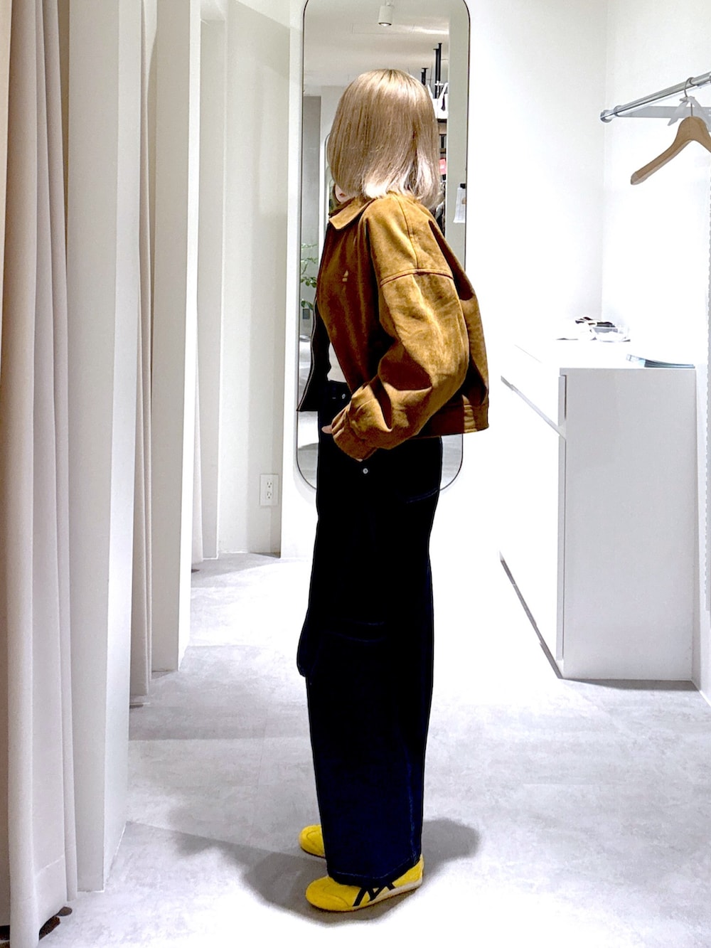 ブルー系のデニムパンツ、ブラック系のショルダーバッグ、ブラウン系のブルゾンを着用したレディースの冬コーディネートの2枚目の写真