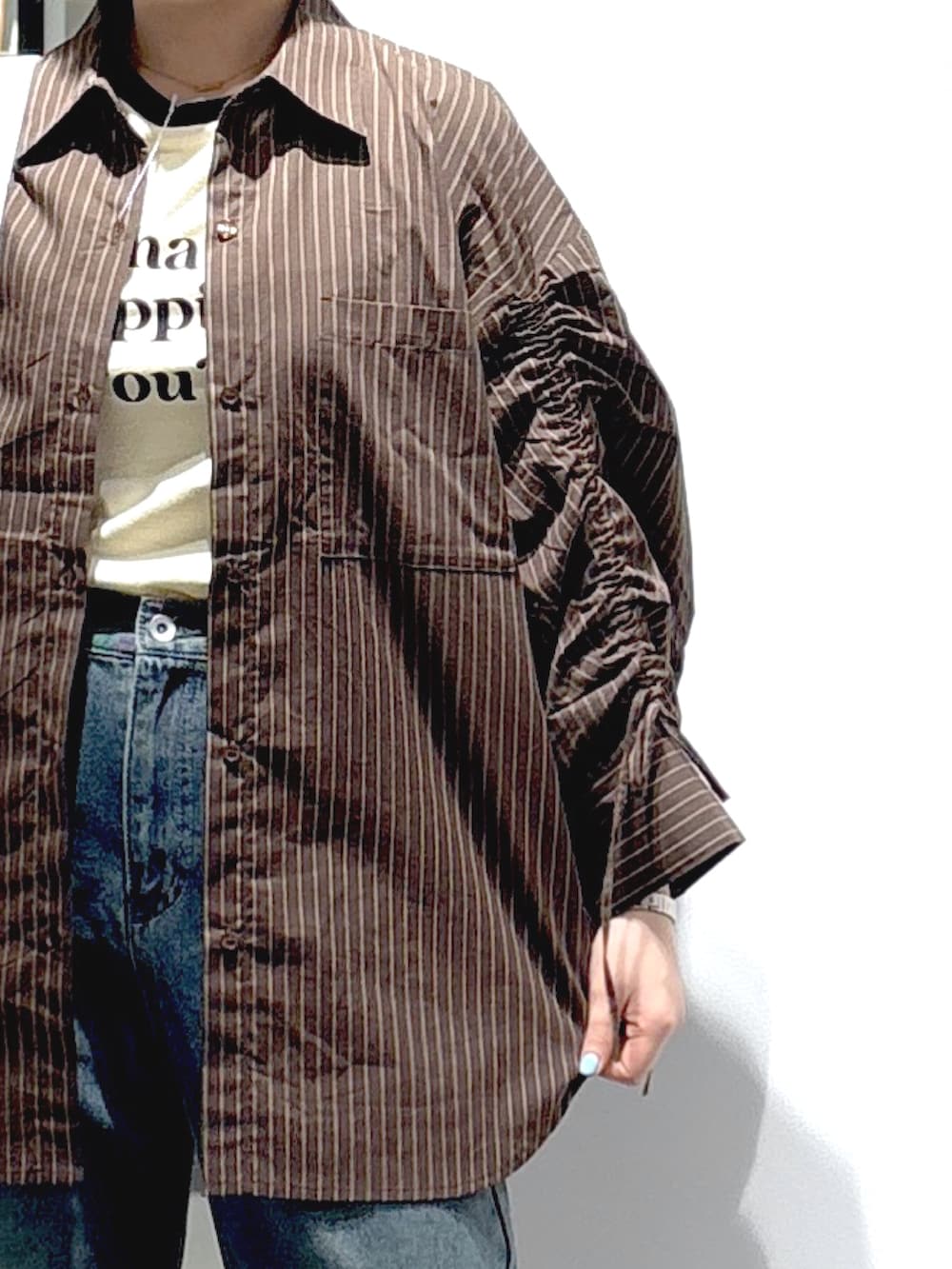 ブラウン系のシャツ/ブラウス、ブルー系のデニムパンツ、ホワイト系のTシャツ/カットソーを着用したレディースの秋コーディネートの4枚目の写真