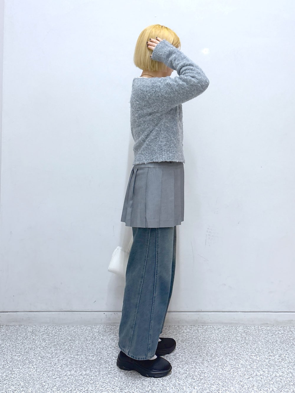 ブルー系のデニムパンツ、グレー系のスカート、グレー系のカーディガン/ボレロを着用したレディースの春コーディネートの2枚目の写真